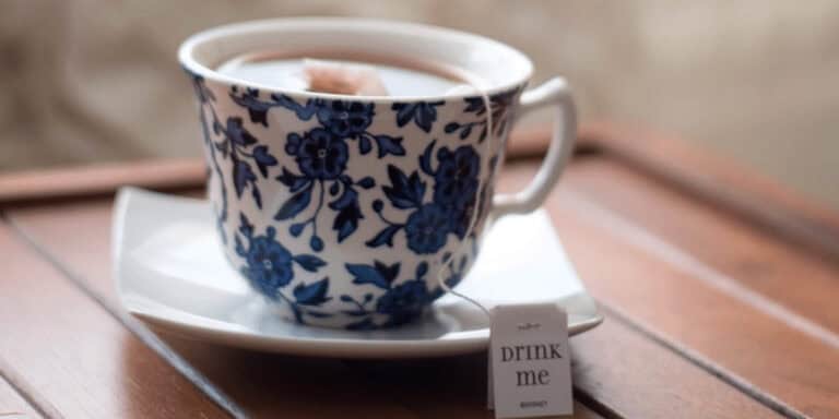 Blue floral teacup with hot beverage on wooden surface, cozy relaxation, Think About Such Things.