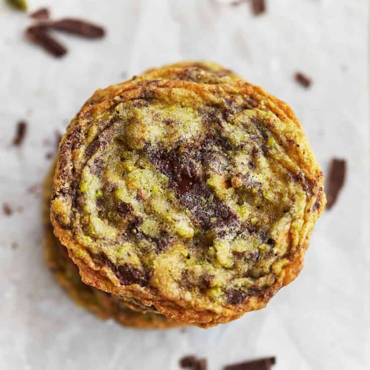 Chocolate chip muffin with a crumbly topping on parchment paper.