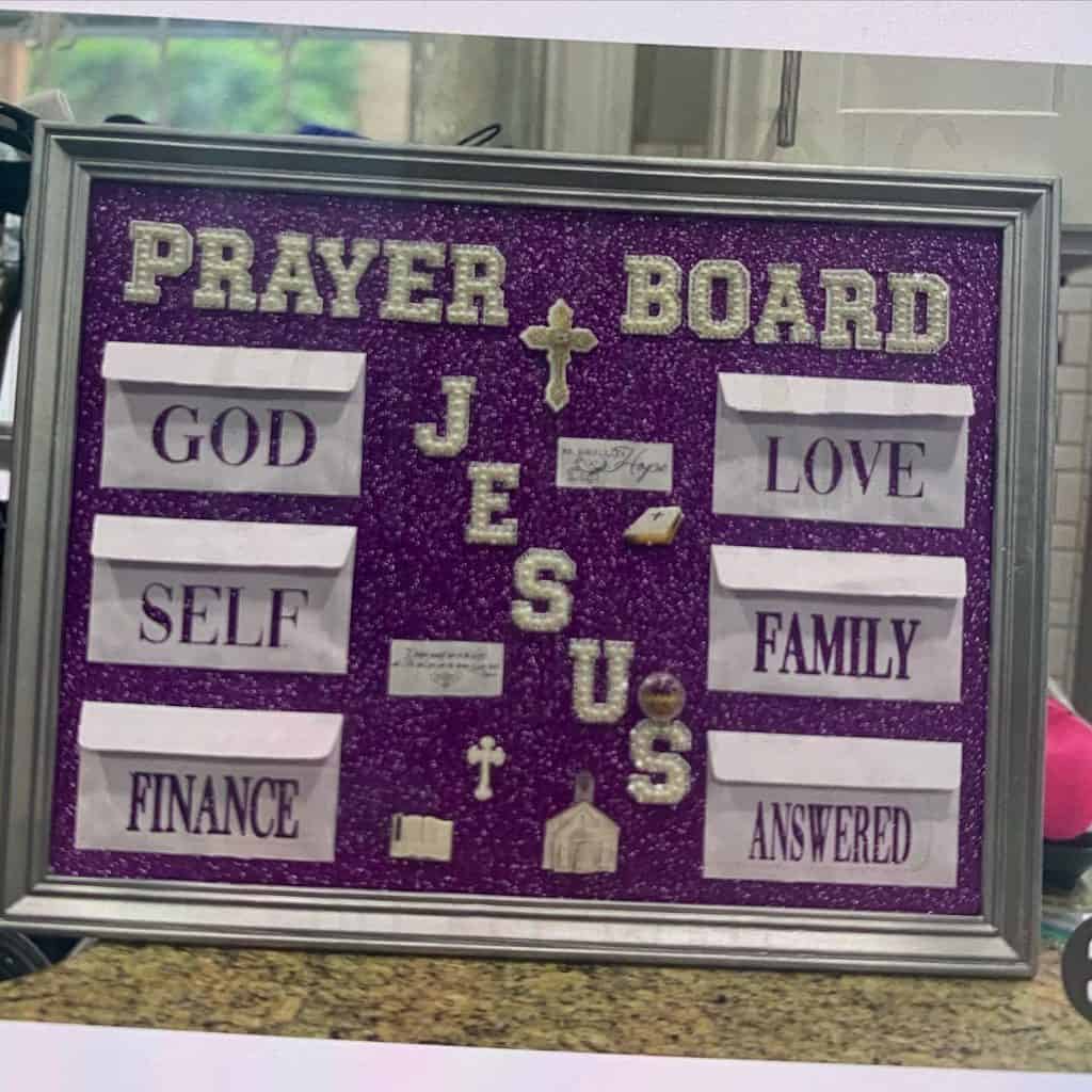 Decorative prayer board with words like God, Love, Family, and Jesus.