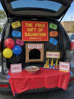Church trunk-or-treat setup with salvation-themed decorations and free gift station.