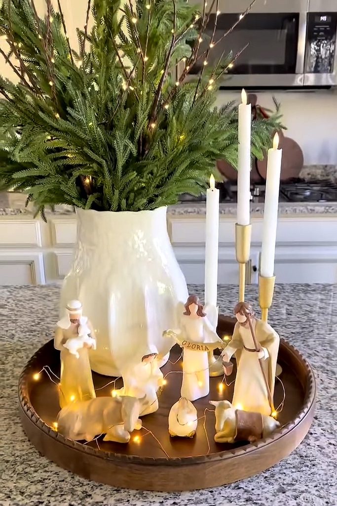 Nativity scene with candles and greenery for Christmas decoration.